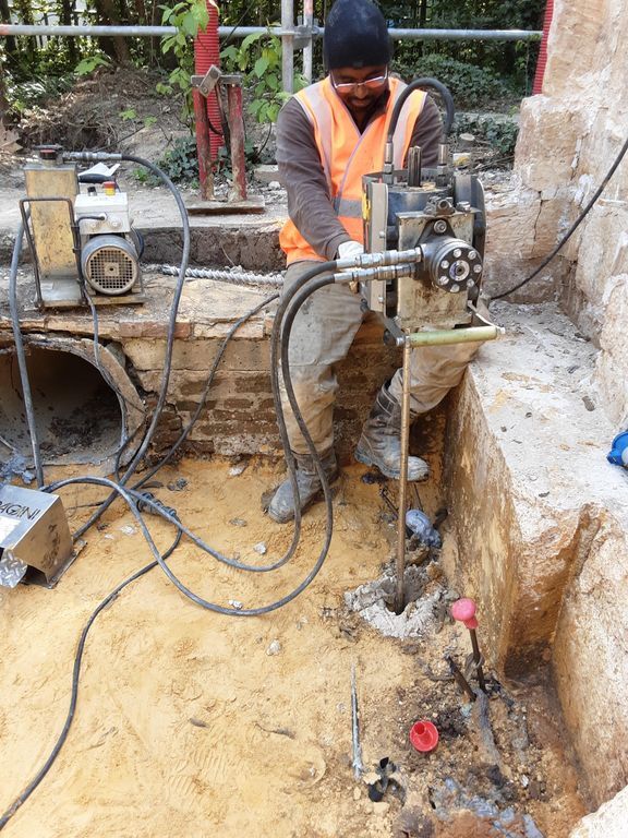 Ouvrier Uretek creusant le sol du chantier