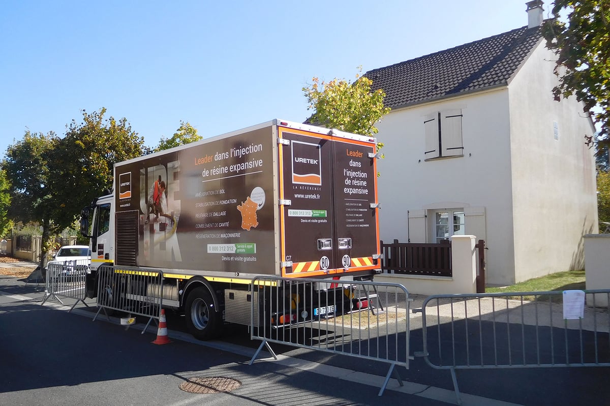 Camion d'intervention URETEK devant une maison fissurée 