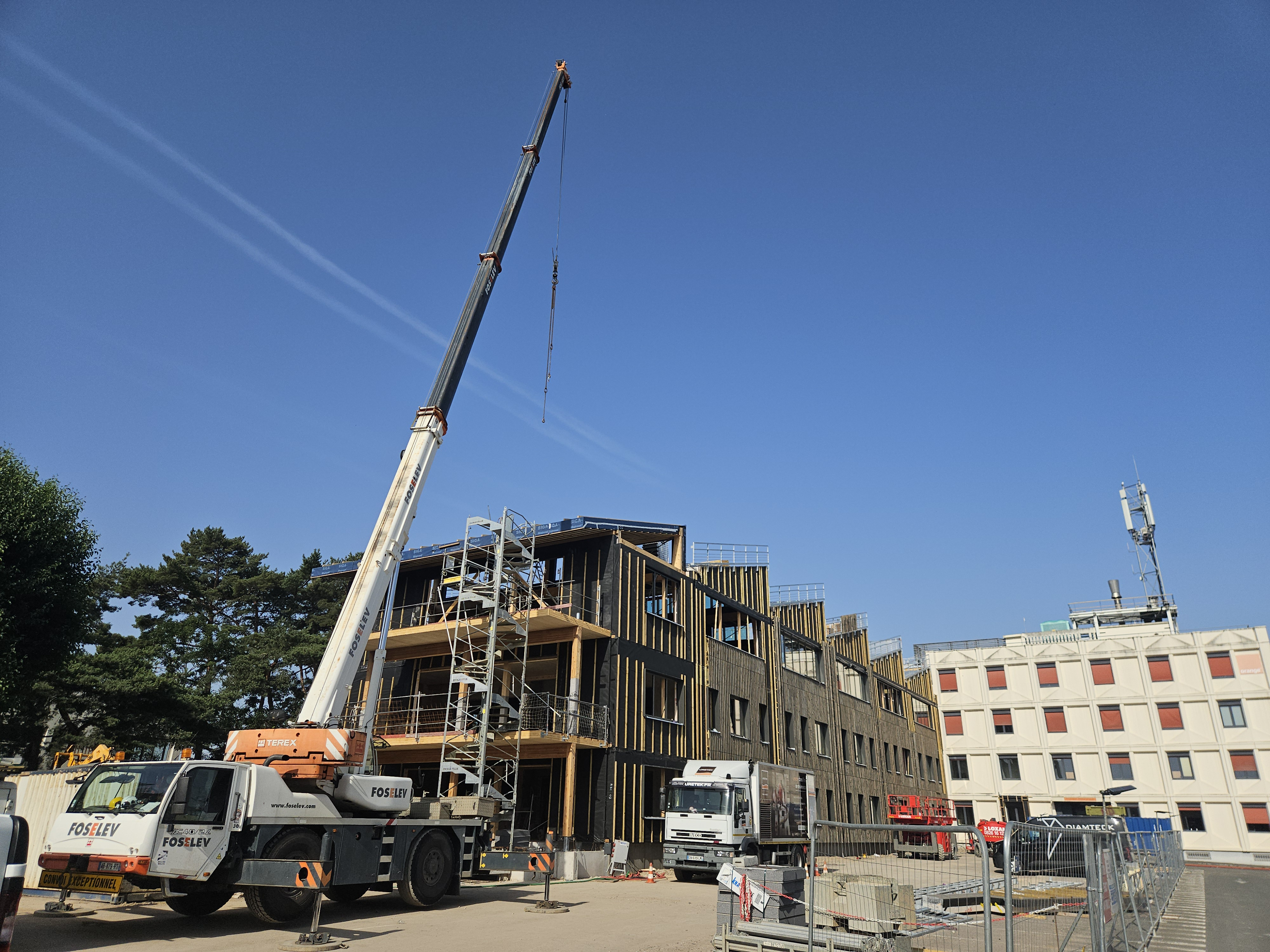 Grue de chantier en action devant la surélévation du site .