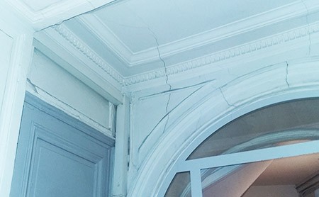 fissures verticales intérieures sur les murs et le plafond d'un immeuble