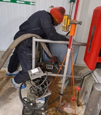 Technicien Uretek injectant la résine bi-composant dans les sols pour consolider le soubassement 