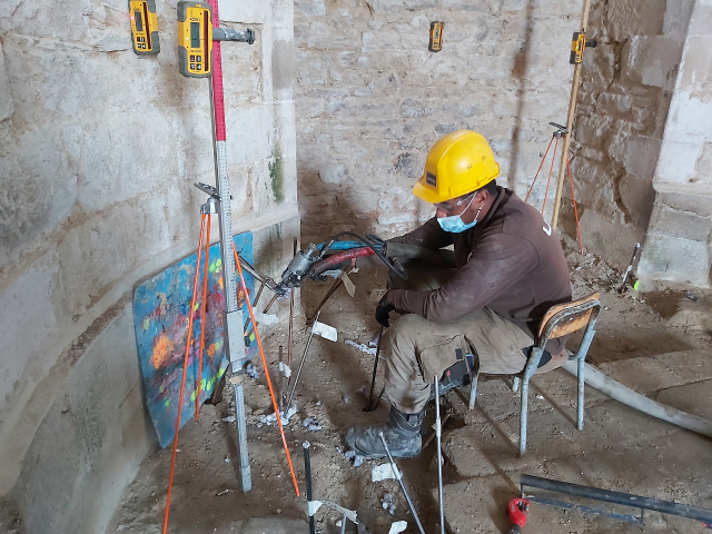 Photo d'un technicien URETEK injectant de la résine expansive dans le sol de la chapelle Saint-Yves à Vannes