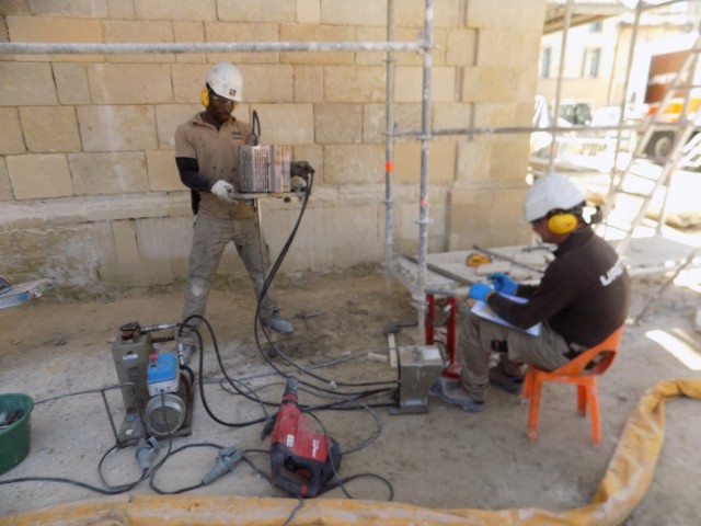 Injection de résine par 2 techniciens URETEK dans le sol sous fondation d'une église dans l'Hérault pour stabiliser l'ouvrage