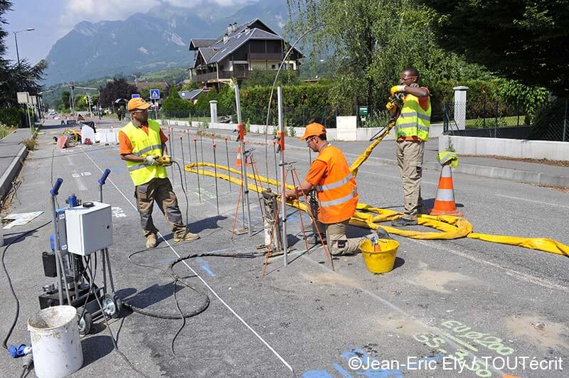 Photo de techniciens uretek stabilisant une route départementale en Savoie  grâce à l'injection de résine expansive