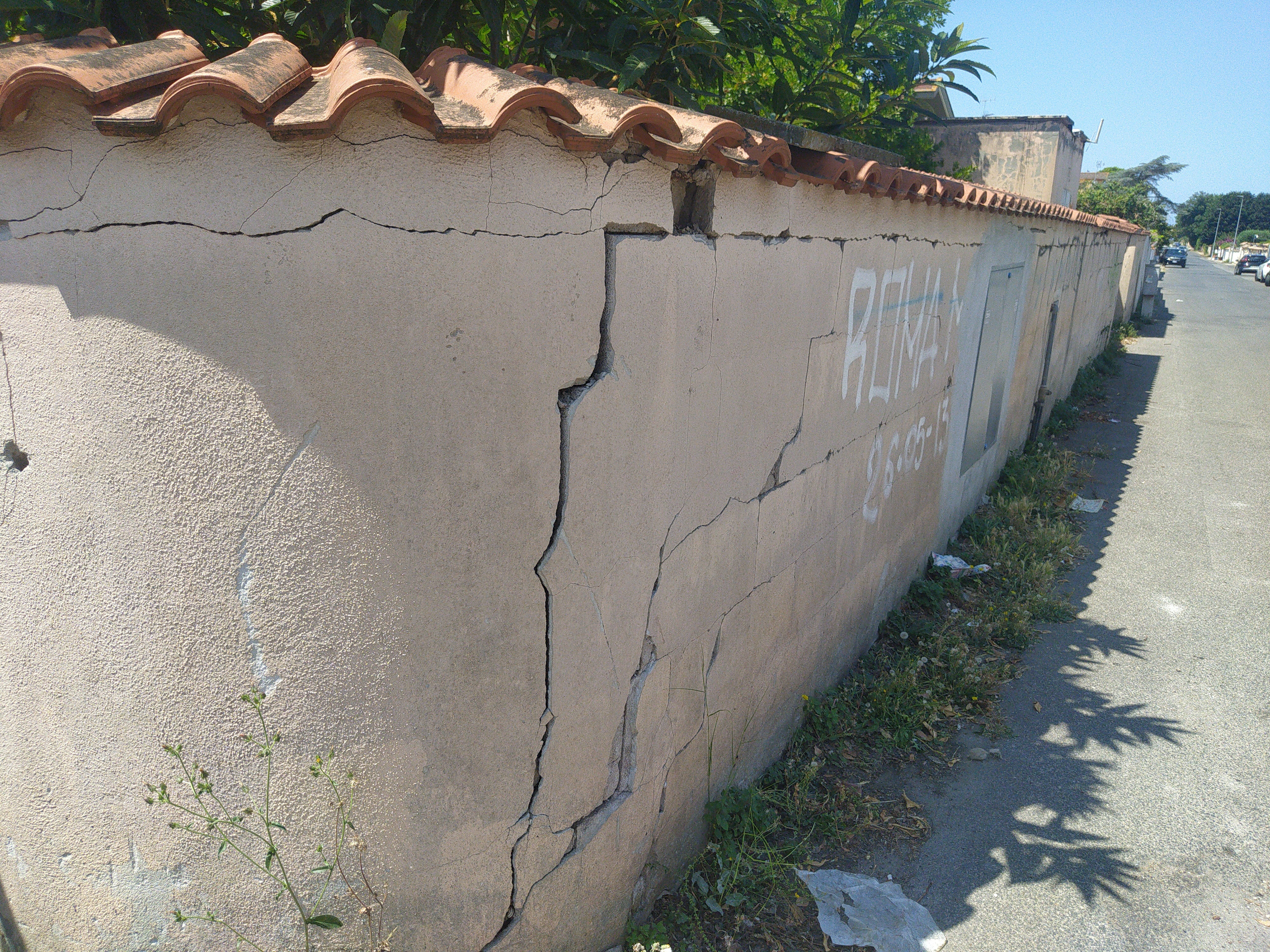 Fissures sur un mur entre une extension et le bâtiment principal après tassement différentiel