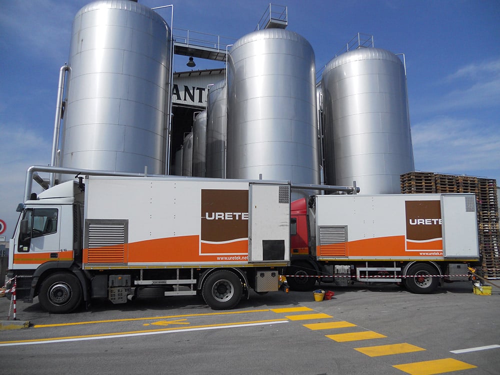 2 camions uretek devant un site industriel avant une intervention