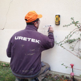 Rebouchage des trous dans un mur par un technicien uretek