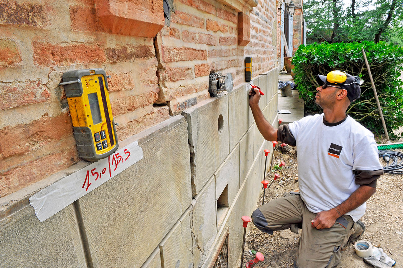 Mise en place de niveau laser pour suivre les réactions du château stabilisé par URETEK. Ses murs étaient fissurés et affaissés